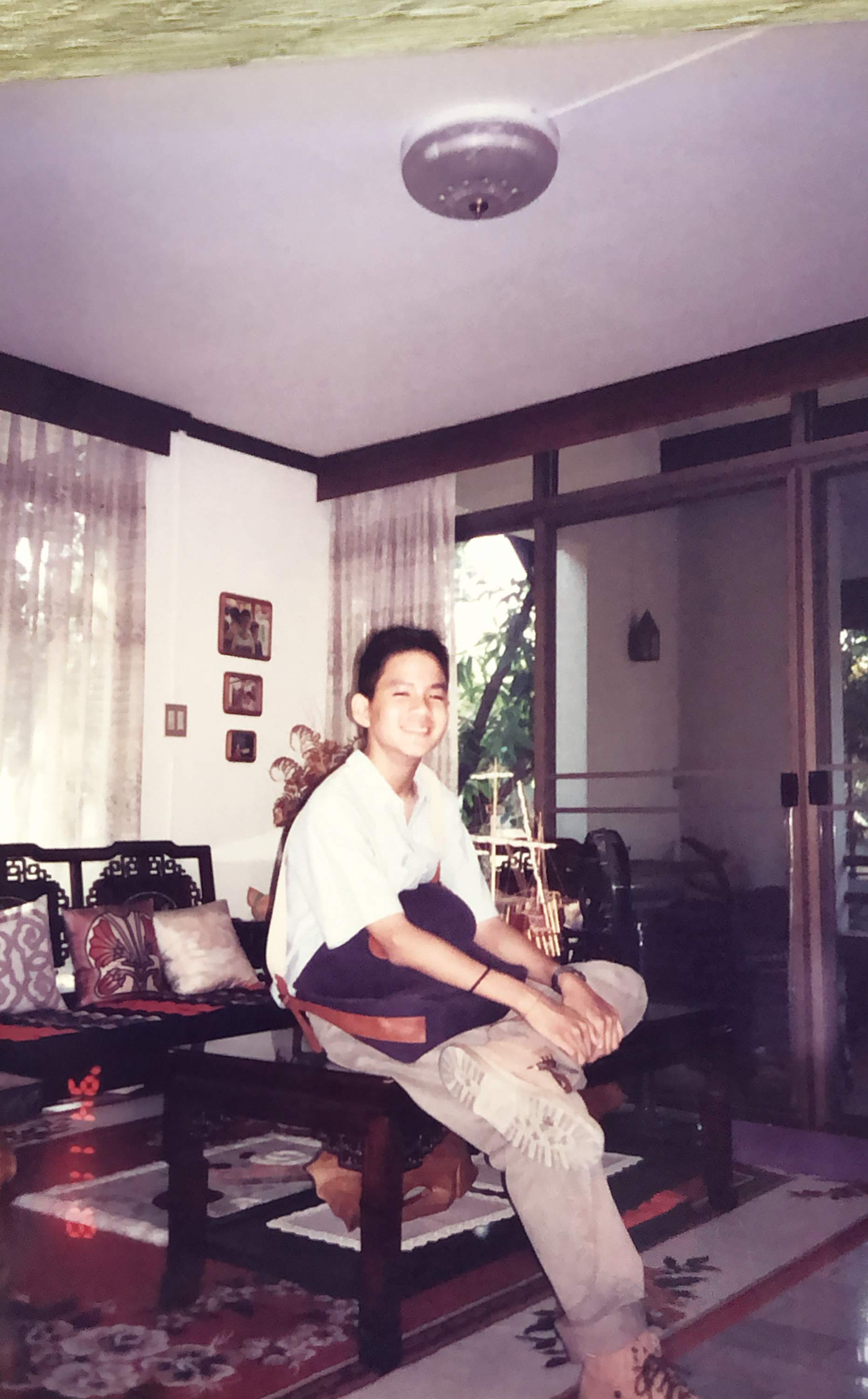 Non as a boy in the living room of the family house, Bangkok